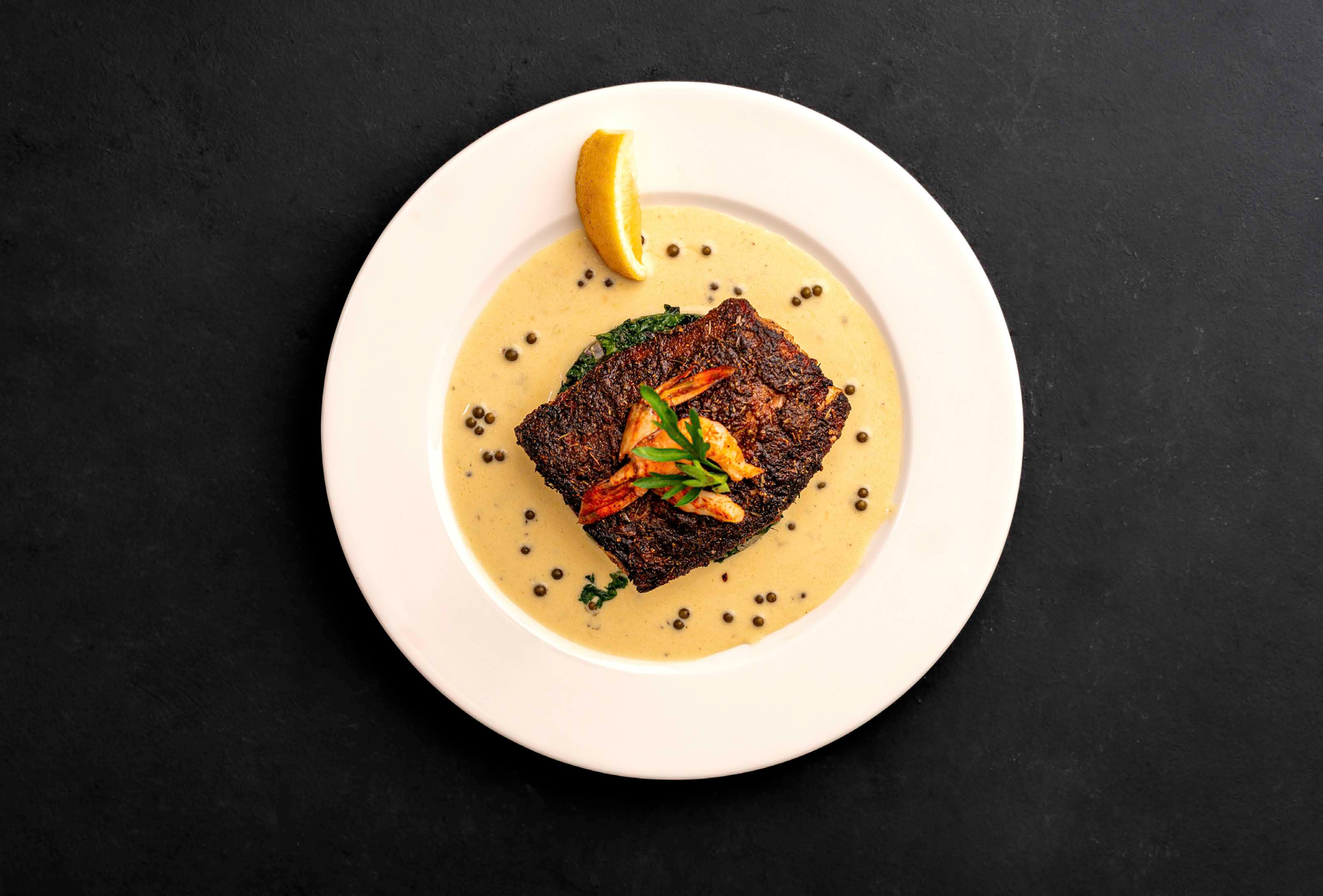 Carefully plated dish on a pale plate against a dark background