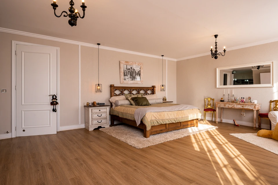 Sunlit bedroom with timber flooring and pale walls