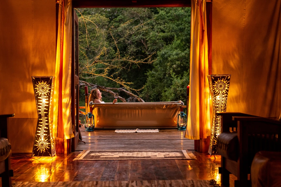 Warmly lit interior opening towards an outdoor bath