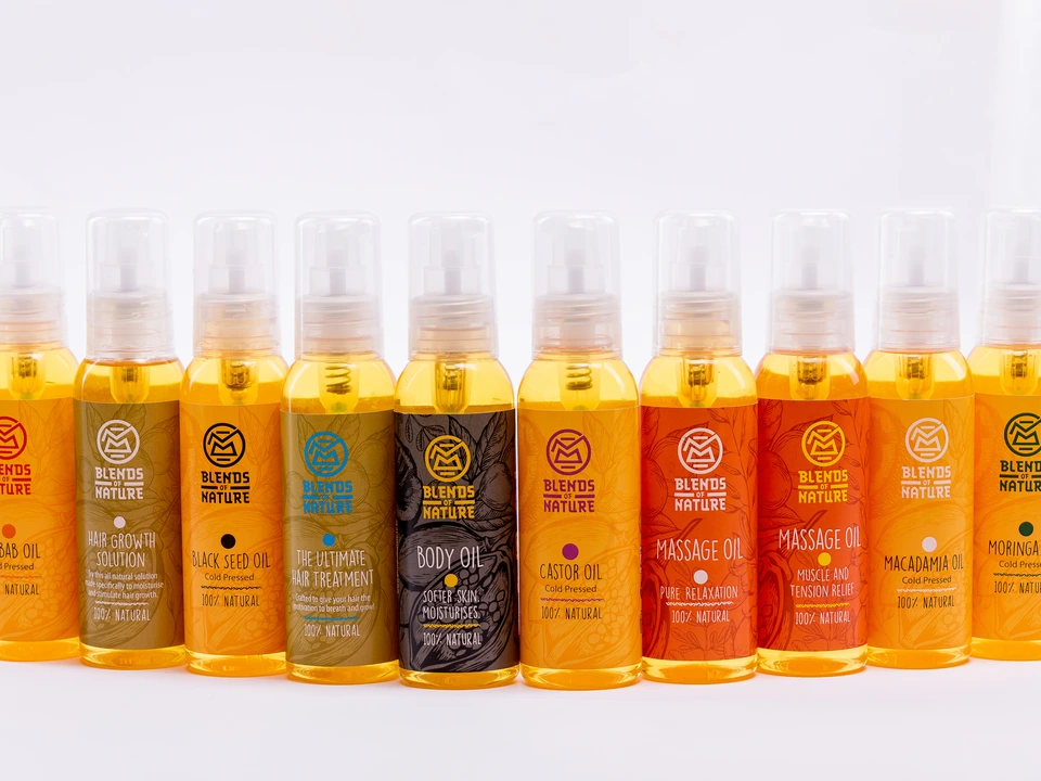 Row of small product bottles containing golden liquid against a white background