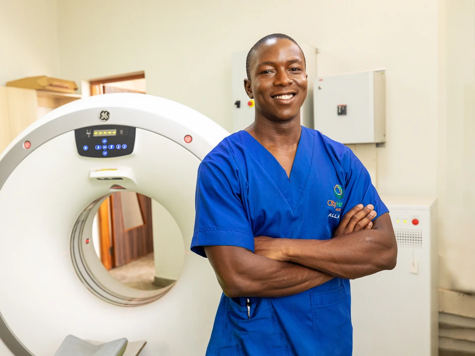 Healthcare professional in blue scrubs beside medical imaging equipment