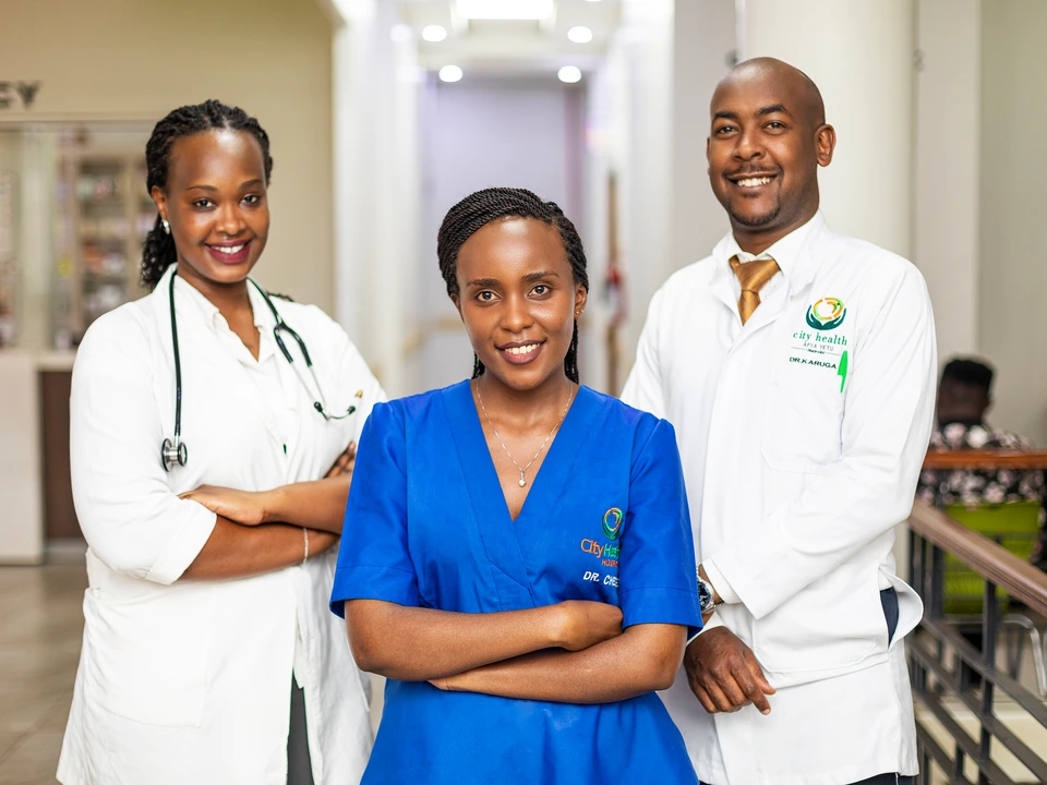 Three healthcare professionals posing together in a clinical setting