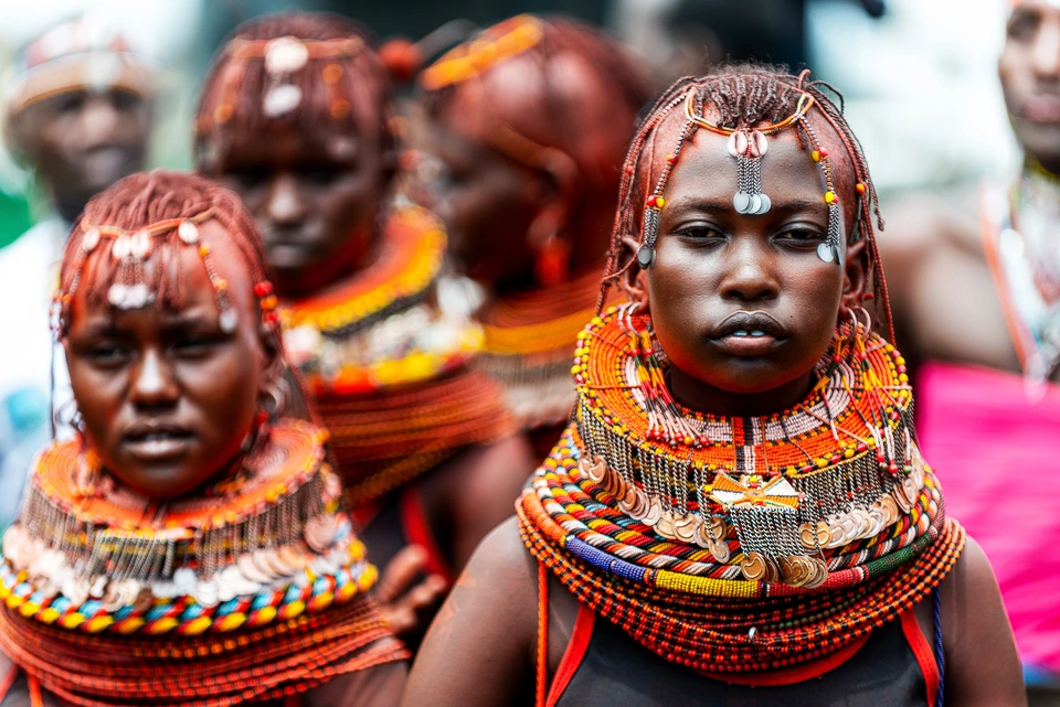 Women wearing layered traditional beadwork at a cultural gathering