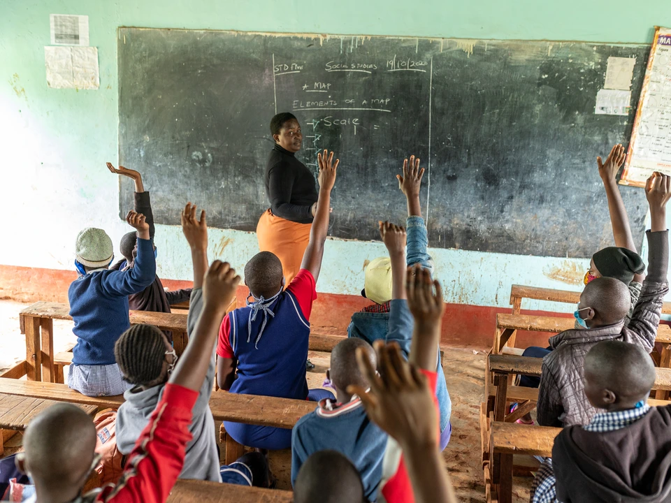 Children raising their hands in a classroom