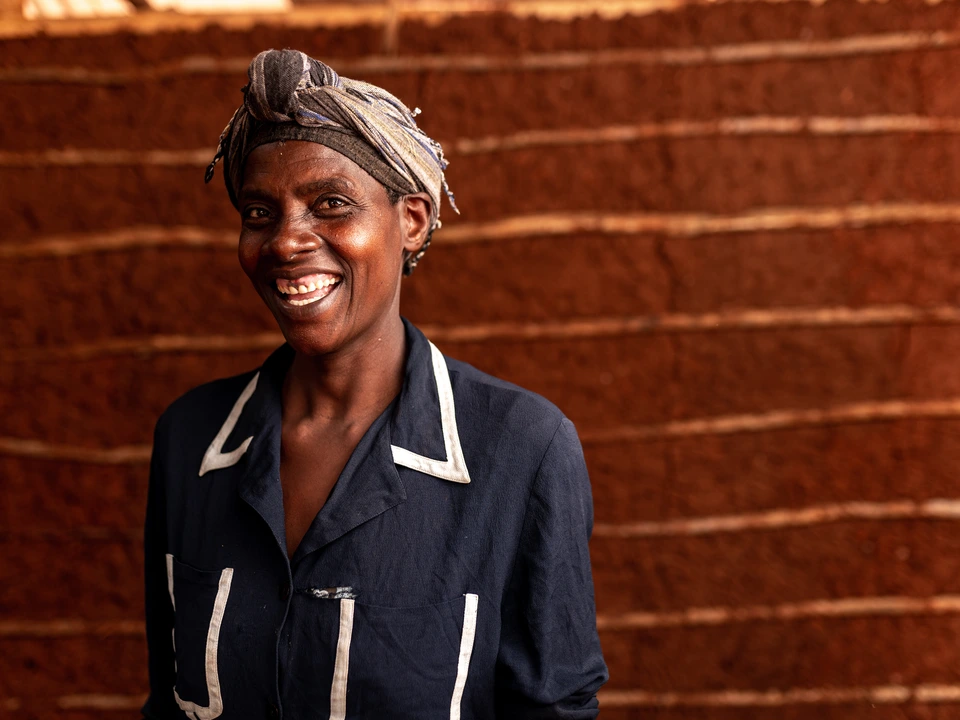 Smiling woman standing beside a brick wall