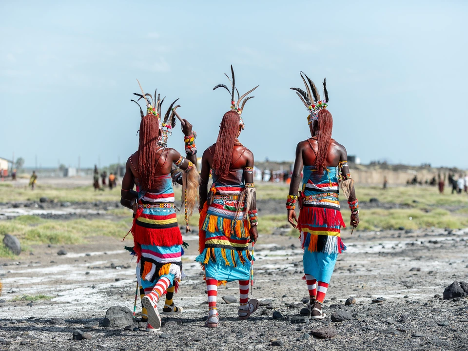 Three dancers in colourful traditional clothing outdoors