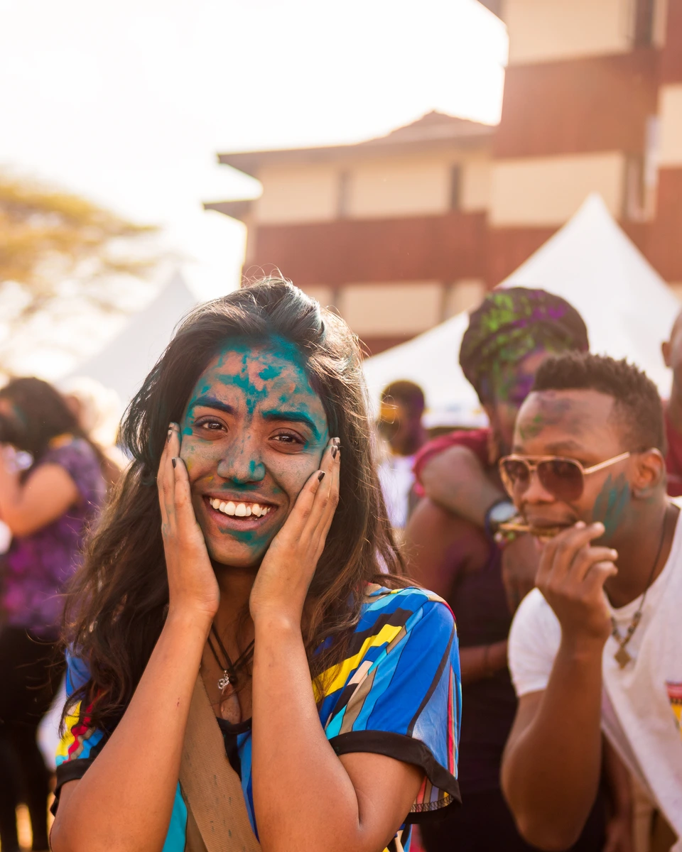Smiling participants with colourful face paint at an outdoor event