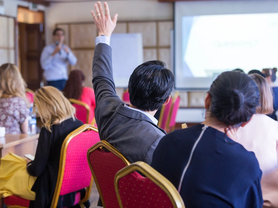 Participants attending a workshop with one person raising a hand