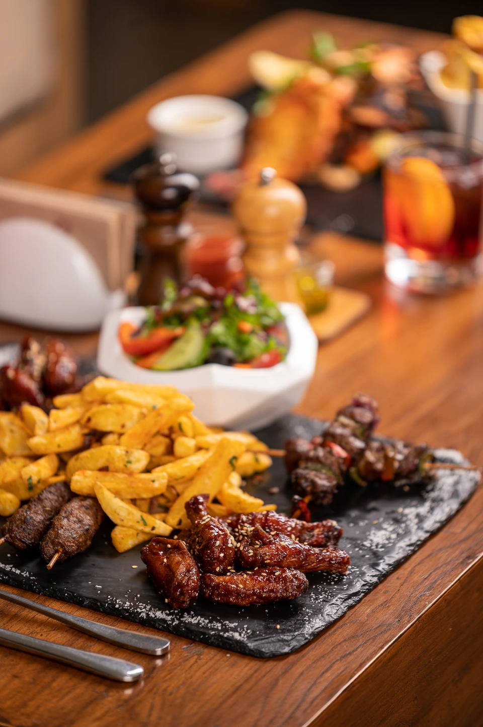 Generous platter of grilled food with side dishes on a restaurant table