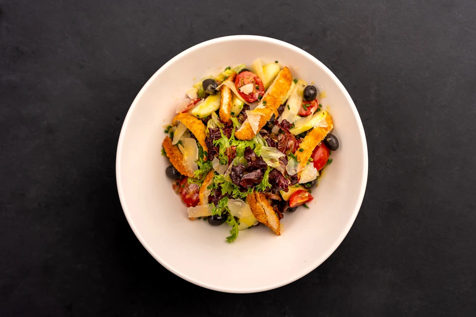Overhead photograph of a colourful salad on a white plate