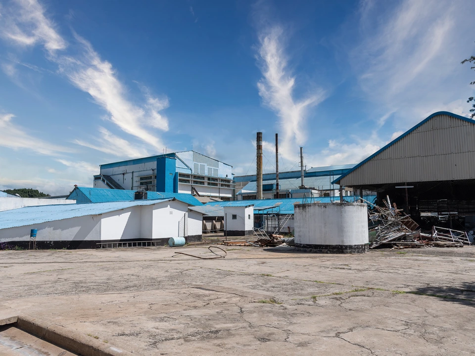 Factory buildings and chimneys beneath a blue sky