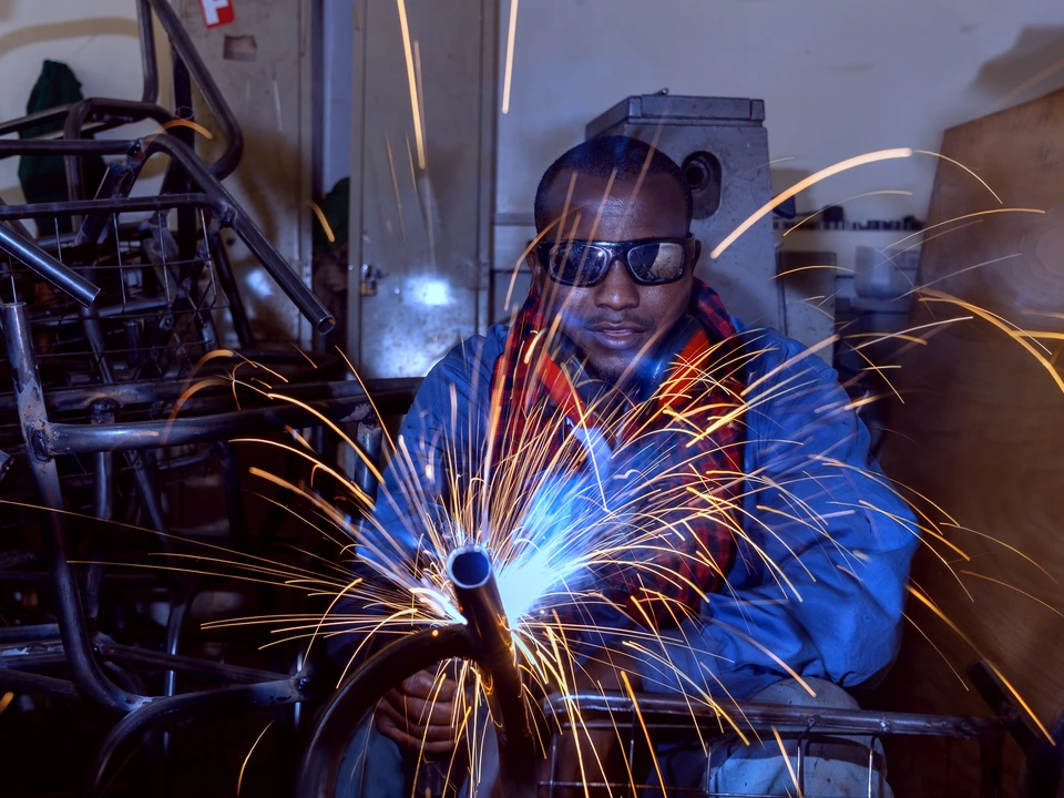 Welder working with bright sparks flying from the metal
