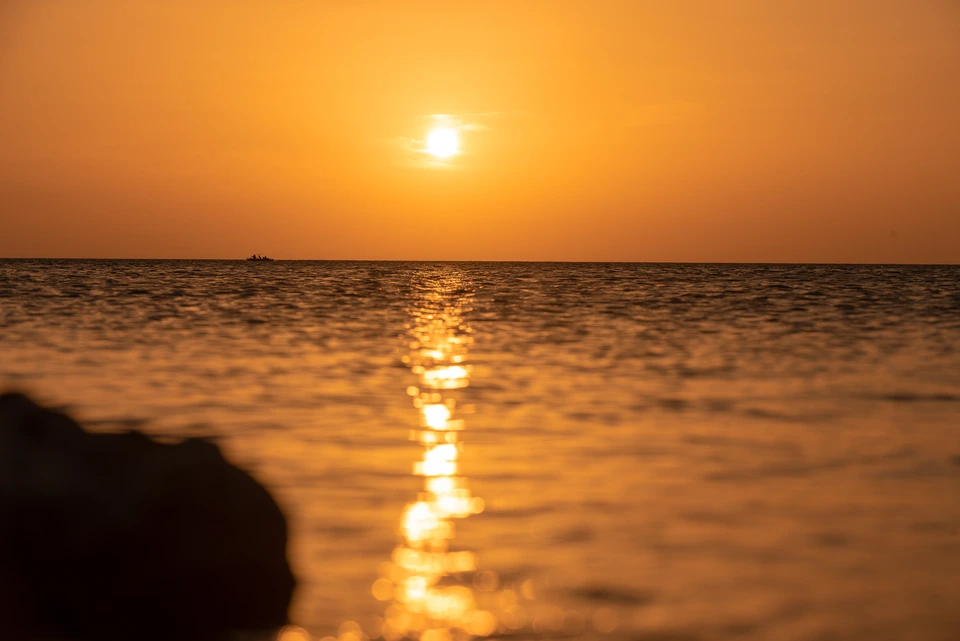 Setting sun casting a golden path across the sea