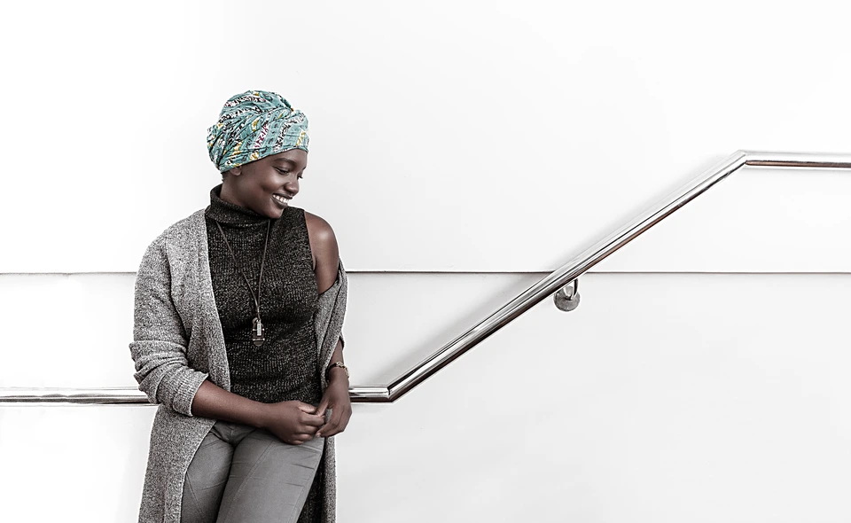 Black and white professional portrait beside a staircase