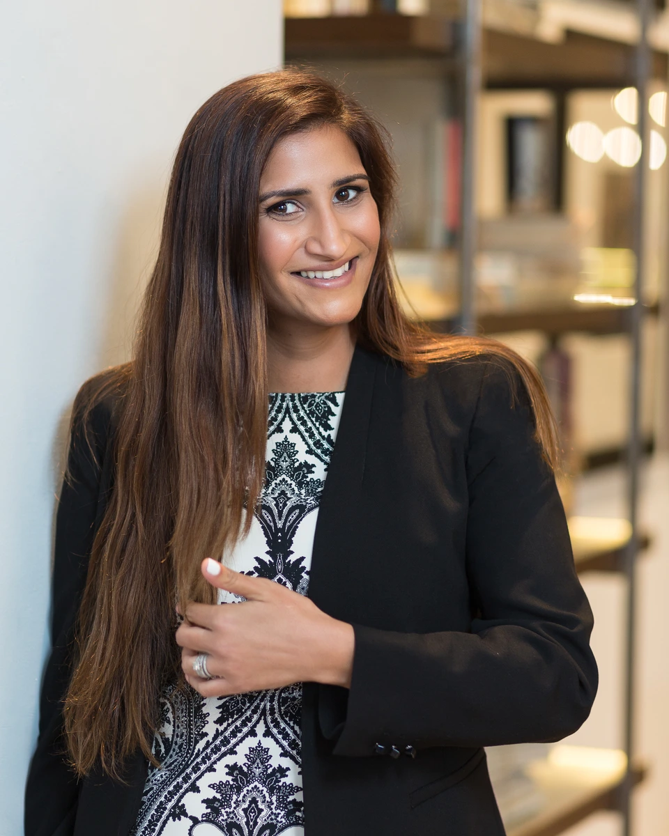 Woman in business attire standing beside shelving