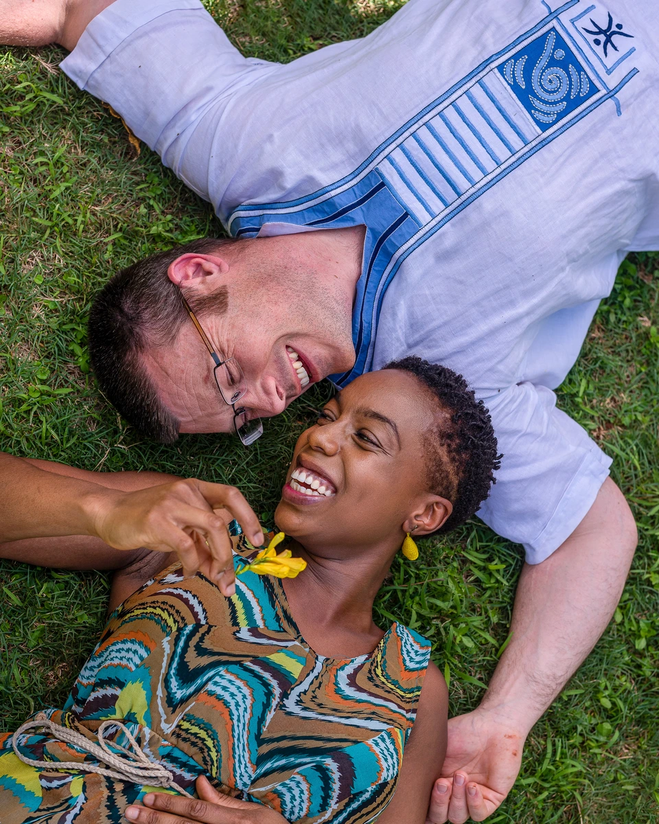 Two people lying together on green grass